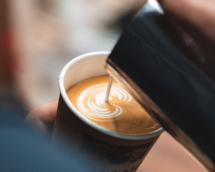 Barista of third wave coffee shop showing off latte art skills