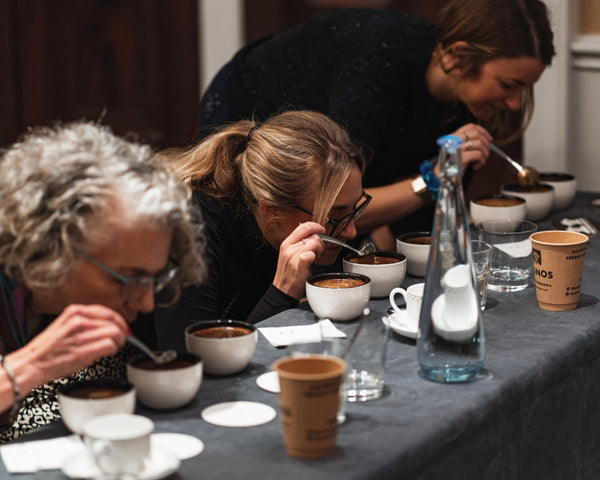 Group analysing and slurping coffee during coffee tasting event