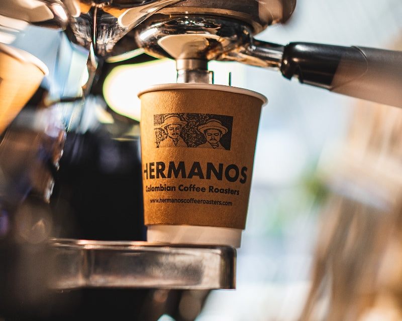 Hermanos takeaway coffee cup illustrating rise in cost of coffee