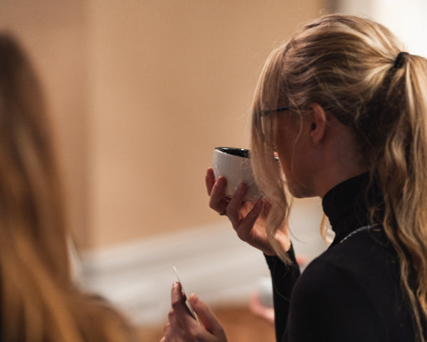 Lady inhales aromas of coffee cup during coffee tasting experience