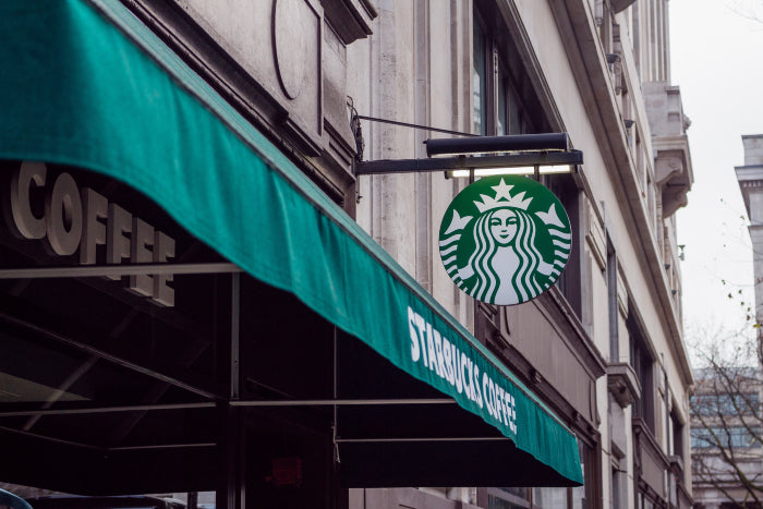 Image of Starbucks logo and shop front representing the second wave of coffee