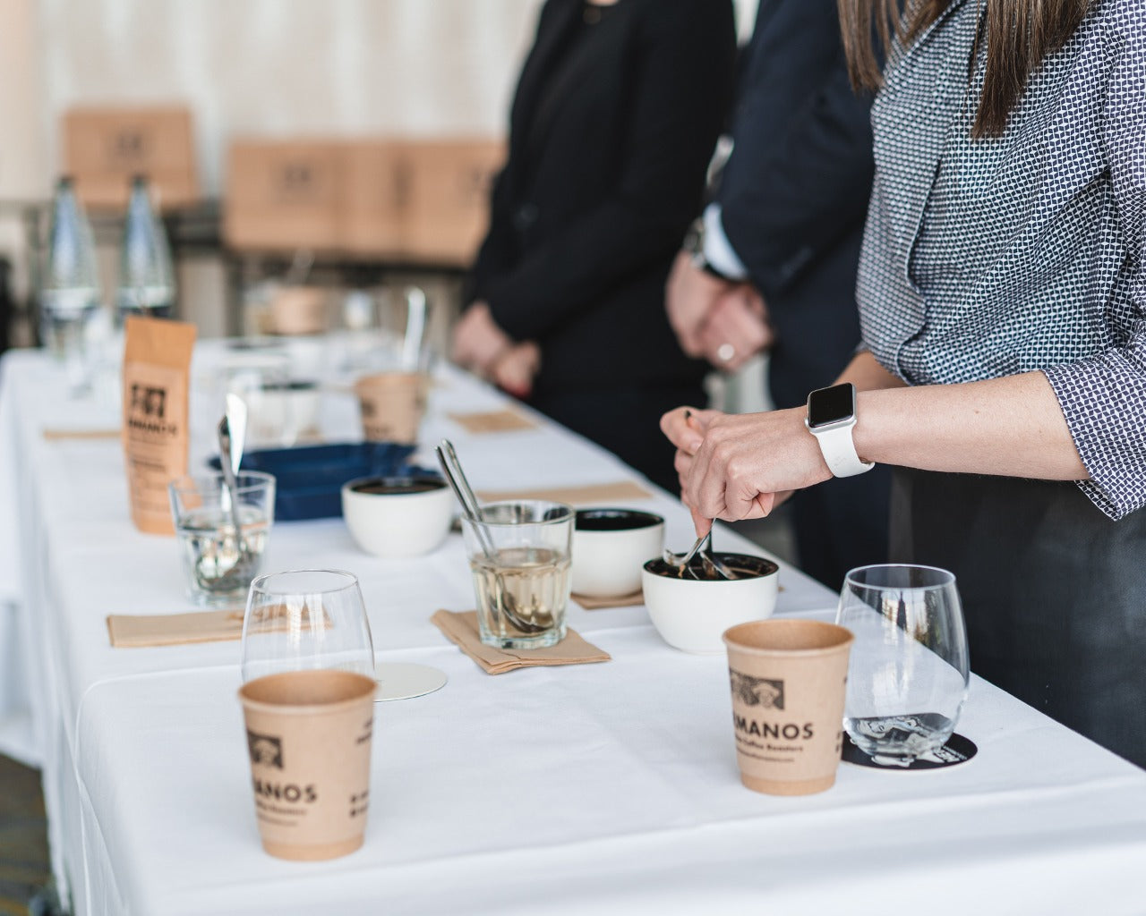 Tasters instructed to rinse spoonts by coffee tasting guide after tasting coffee at coffee cupping experience