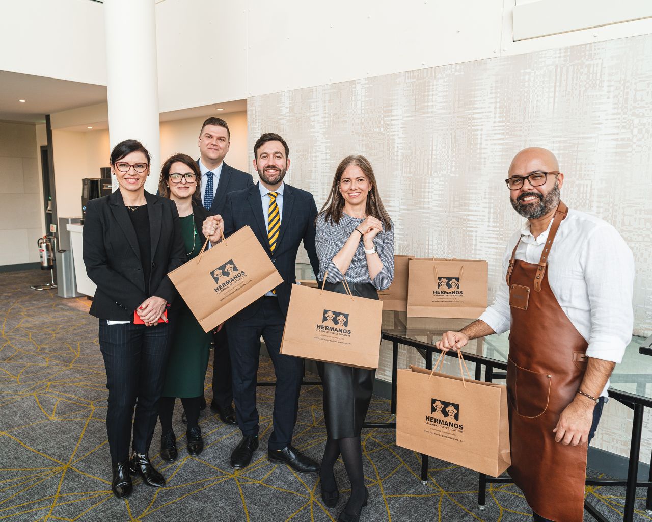 Team of happy colleagues and coffee tasting guide after a coffee tasting event with Hermanos