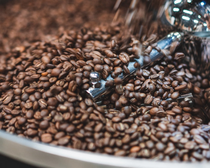 Whole beans falling into Giessen roasting machine before sale